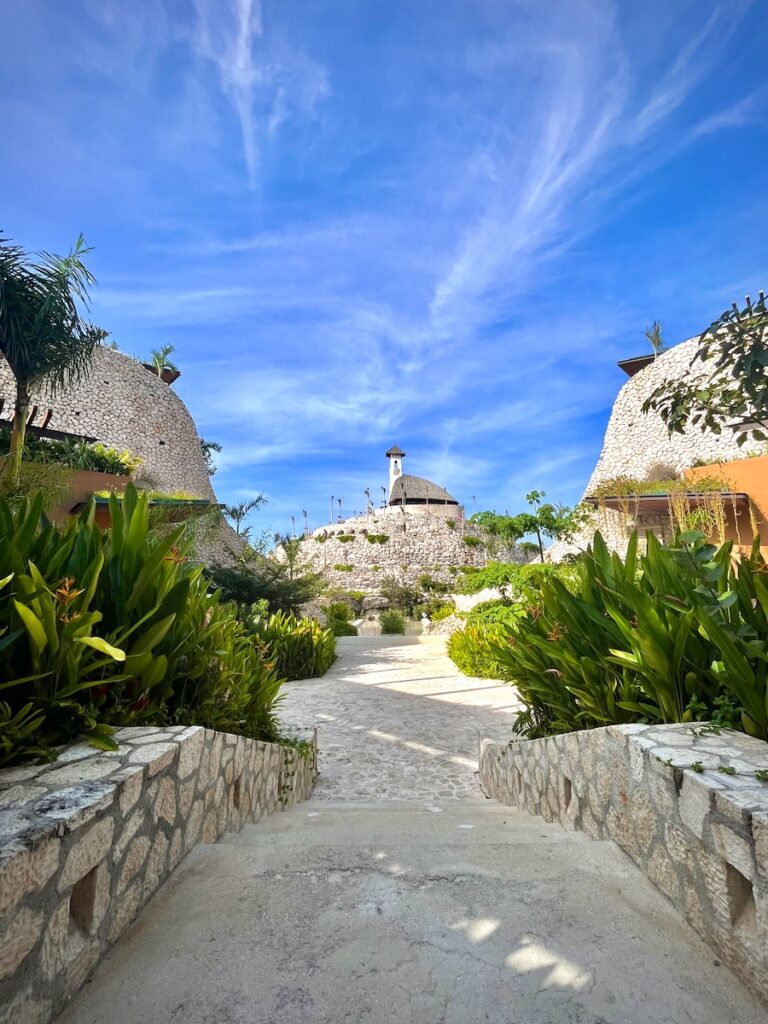 a stone walkway between two buildings and trees